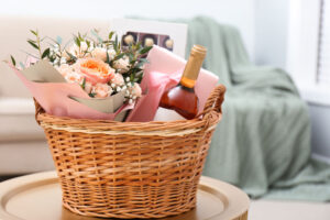 Wicker basket with gifts on table indoors